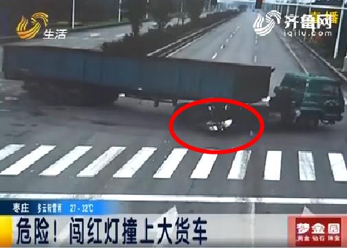 妇女骑摩托闯红灯撞上大货车